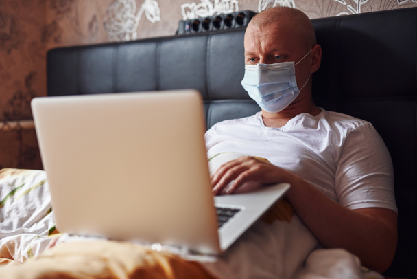 The house has become an office. The patient working remotely at home under a blanket. Get sick with covid. Quarantine restrictions. - Photo, Image
