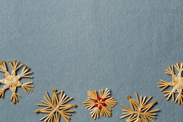Handmade straw snowflakes on a gray background. Horizontally with space. New years layout with snowflakes - 写真・画像