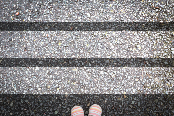 zebra crossing on asphalt with child shoes.  - Photo, Image