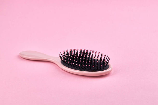 pink hairbrush isolated on a pink coral background with space. beauty hair accessory for hairstyle - Fotó, kép