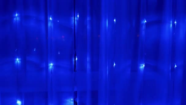 Guirnalda de Navidad de muchas luces led azules parpadeantes en la cortina. 4K - Imágenes, Vídeo