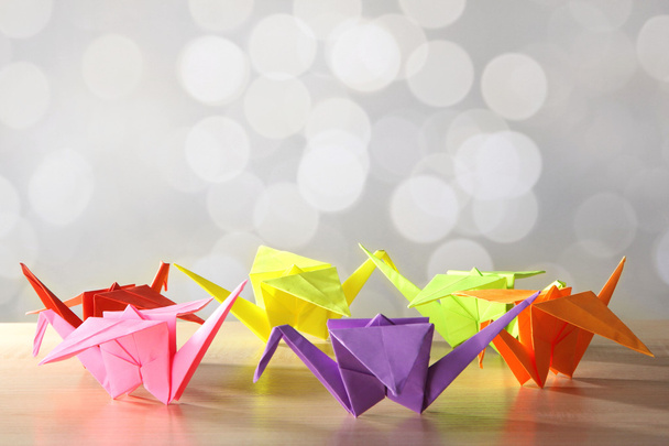 Origami cranes on wooden table, on light background - Zdjęcie, obraz