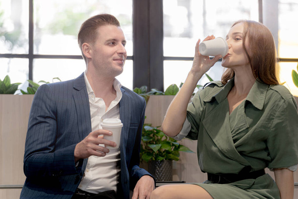Portrait of happy businessman and woman hold cup of coffee at coffee cafe counter bat with nature biophilia for wellness life. - Photo, Image