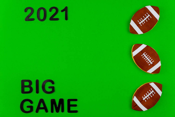 Symbol of american football game with text 2021 on green background. Professional sport background. - Photo, Image