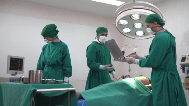 Professzionális sebészek és asszisztensek, akik egy emberi mellkas műtétre készülnek a kórház műtőjében. Kockázatos intenzív ellátásban dolgozó fogamzóorvos és nővér. - Felvétel, videó