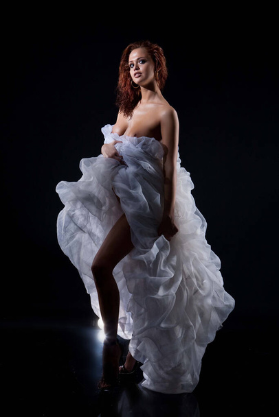 Young nude woman with white dress on a black background - Foto, Imagem