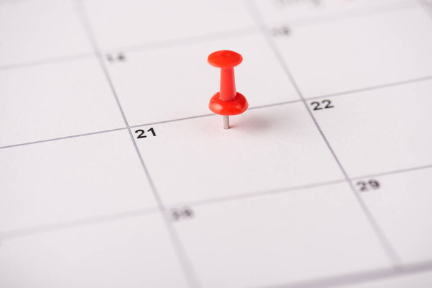 Close up zobacz zdjęcie czerwonego pinezki na 21 daty w białym kalendarzu - Zdjęcie, obraz