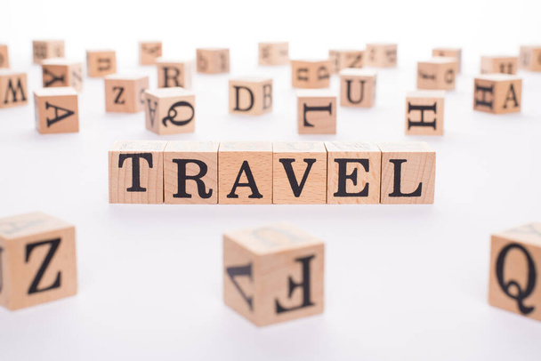 Travel concept. Close up view photo of wooden cubes making showing word travel isolated white background - Photo, Image