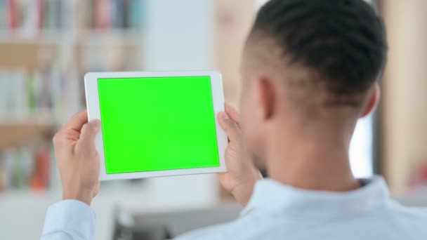 Αφρικανική Man Watching Tablet με πράσινο Chroma βασική οθόνη, πίσω όψη  - Πλάνα, βίντεο