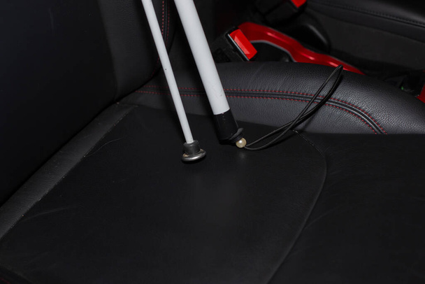 Składana biała trzcina na siedzeniu pasażera pojazdu - Zdjęcie, obraz
