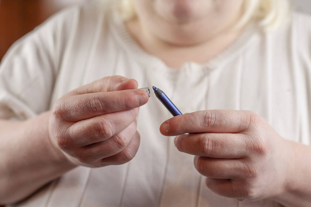 Woman removing the cap from blue eyeliner that she is ready to use - Photo, Image
