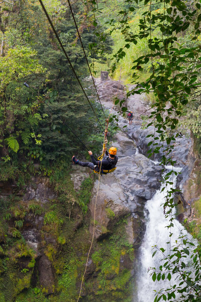 A young man riding on a zip line rope in an extreme adventure jungle in Xico, Veracruz, Mexico - Φωτογραφία, εικόνα