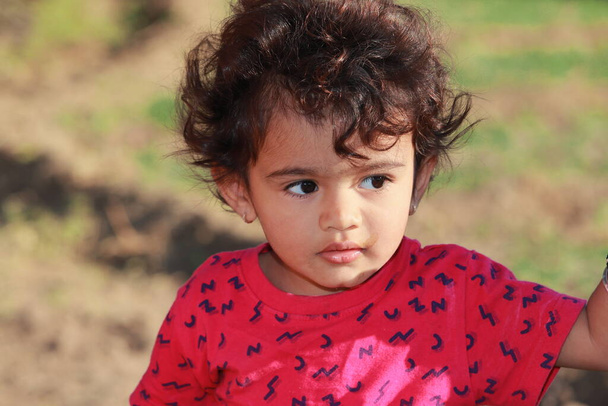 Foto de cerca de la hermosa cara de niño indio y el uso de un vestido rojo - Foto, imagen