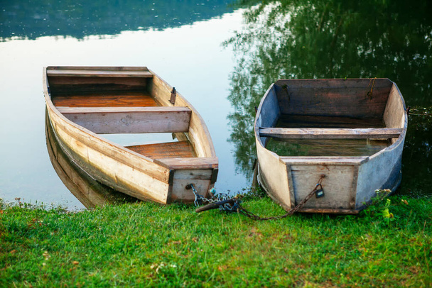 Ribera idílica con botes de madera. Orilla verde del río con barcos de pesca  - Foto, imagen