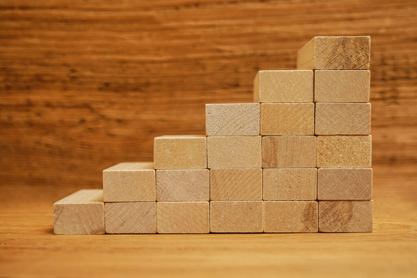 Concept of growth in business, stack of wooden blocks on wooden board background. - Valokuva, kuva