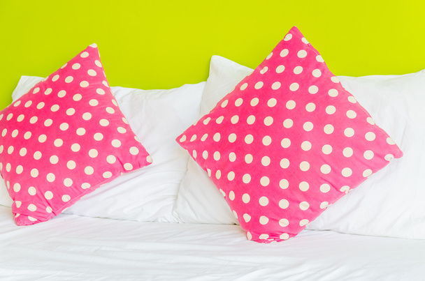 Colorful polka pillow on white bed - Photo, Image