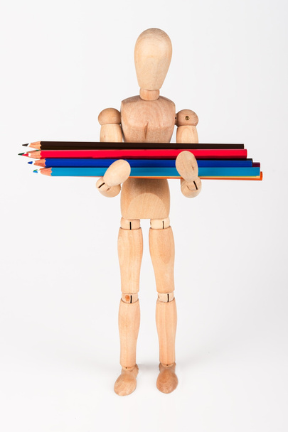 Small wood mannequin standing with bunch of colour pencil isolat - Fotó, kép