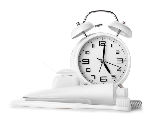 Beyaz arkaplanda çalar saat, yapıştırma ve diş fırçaları - Fotoğraf, Görsel