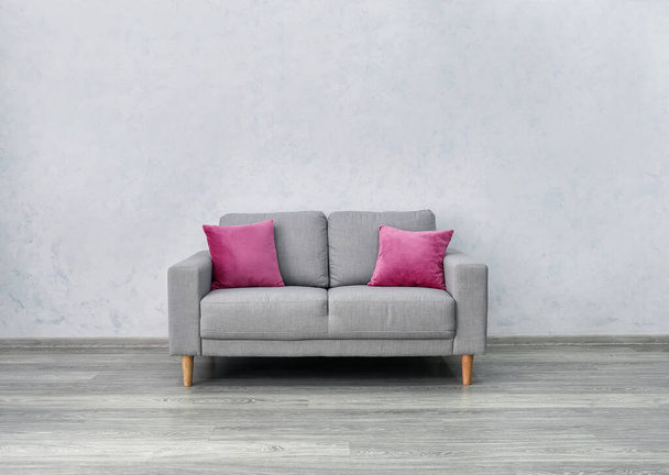 Κομψό άνετο καναπέ κοντά στο φως τοίχο - Φωτογραφία, εικόνα