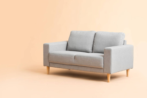 Stylish cozy sofa on color background - 写真・画像
