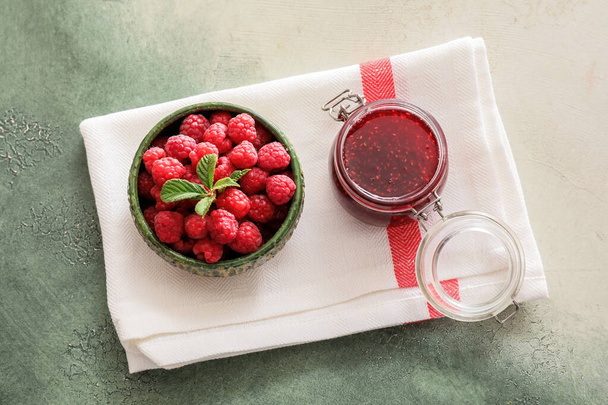 Jar with sweet raspberry jam and bowl with berries on table - Photo, Image