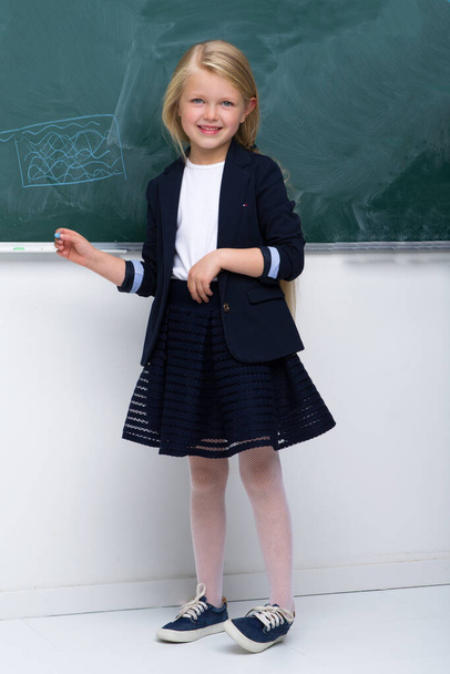 Beautiful schoolgirl standing at blackboard - Valokuva, kuva