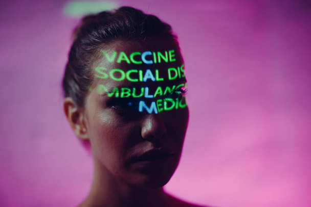 Junge erwachsene Frau mit Wort Ruhe, zusammengesetzt aus den Wörtern Impfen Sozialer Abstand Krankenwagen und Krankenversicherung auf ihrem Gesicht - Foto, Bild