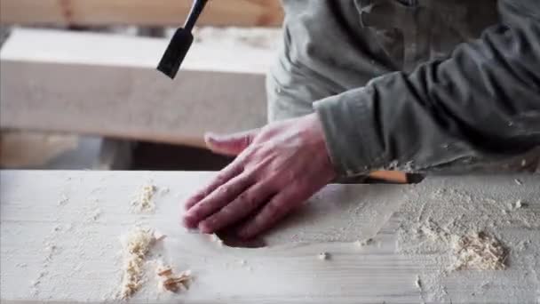 Een onbekende timmerman werkt zorgvuldig met beitel in zijn werkplaats - Video