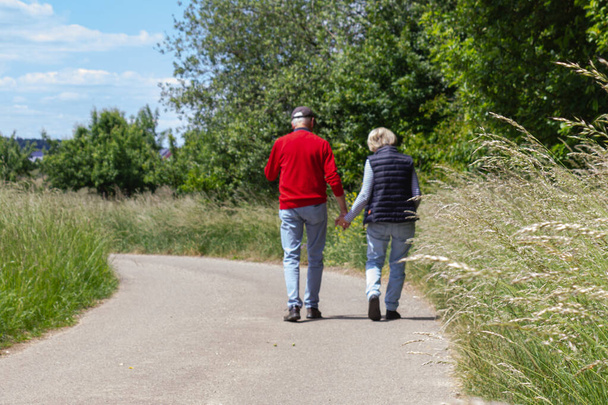 senior couple walking outdoor on a sunny noon in germany - Photo, Image