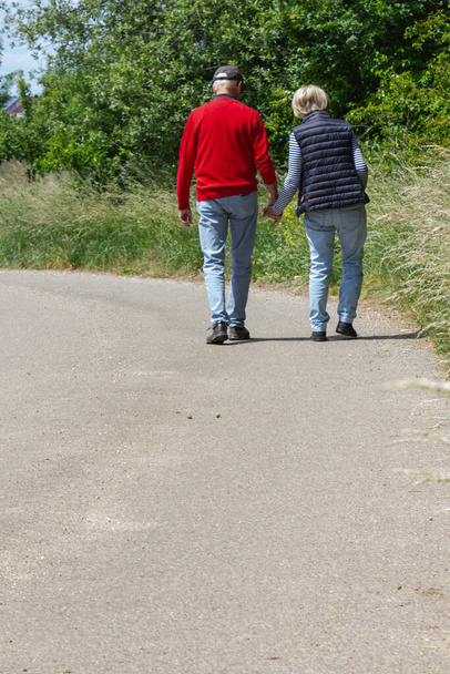 senior couple walking outdoor on a sunny noon in germany - Фото, изображение