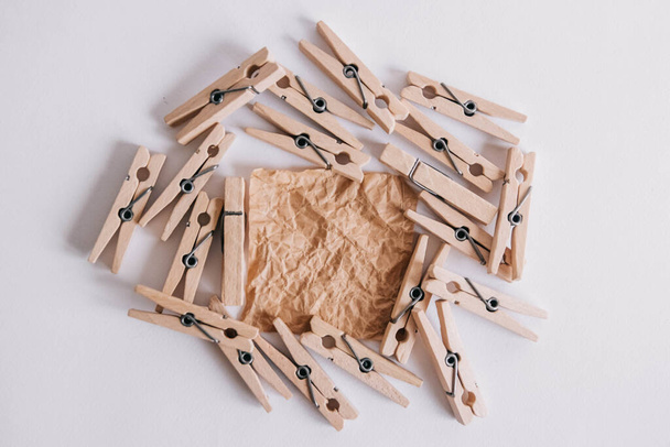 Woodenl clothespins, paper clip and brown sticker on white background. Isolated on white. View from above. Place for your text. - Foto, Bild