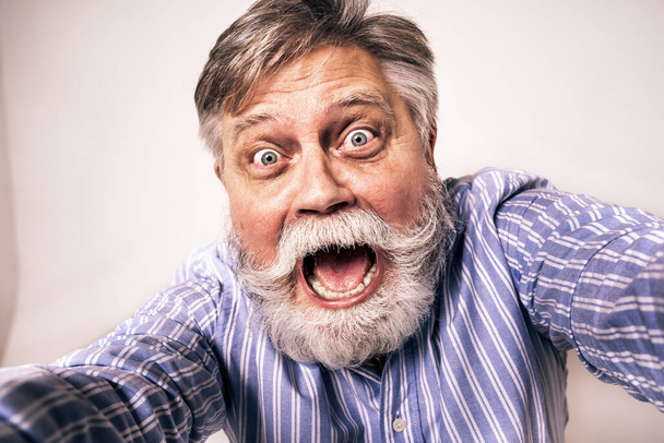 Eccentric senior man with funny expression portrait on background - Active and youthful old male - Foto, immagini