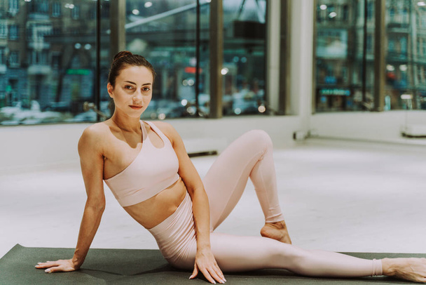 Beautiful athletic woman training in a gym, doing stretching exercises before the workout - Pretty young girl training alone - Fotografie, Obrázek