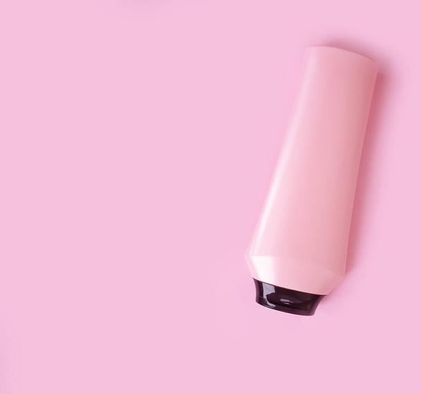 bottle of shampoo and balm on a colored pink background - Photo, image