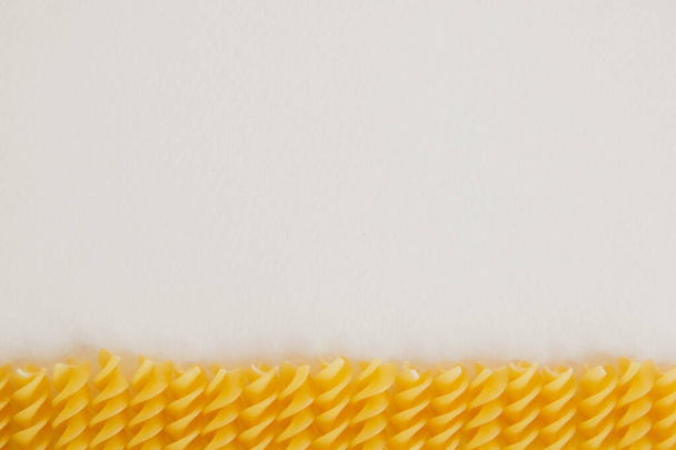 Spiral pasta on a white background. Closeup of raw helix-shape fusilli macaroni on white background. Copy, empty space for text. - 写真・画像