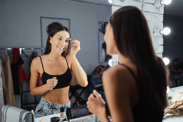 Reflexão da jovem bela mulher aplicando sua maquiagem - Foto, Imagem