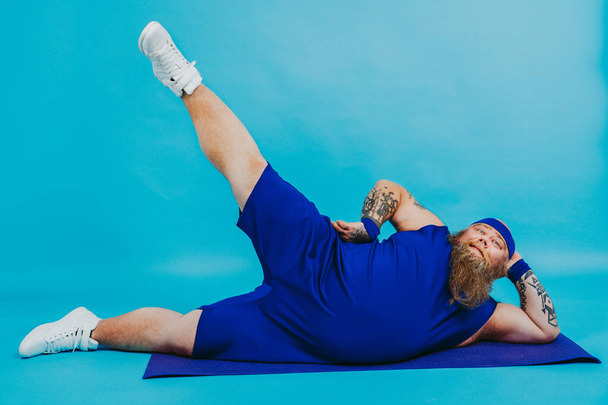 Funny fat man doing some sport exercises - Overweight man having weight issue and tries to start diet and sport, funny character - 写真・画像