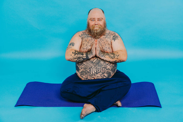 Funny fat man doing yoga meditation, funny and ironic character - 写真・画像