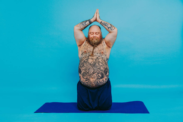 Funny fat man doing yoga meditation, funny and ironic character - Photo, image