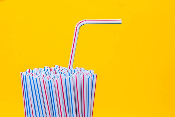 Drinking plastic straws on a yellow background. Colorful of plastic straws used for drinking water or soft drinks. Selective focus. Copy space. - Photo, Image