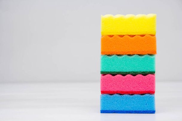 Multicolored sponges for cleaning and washing dishes on a white table. Space for text. - Photo, Image