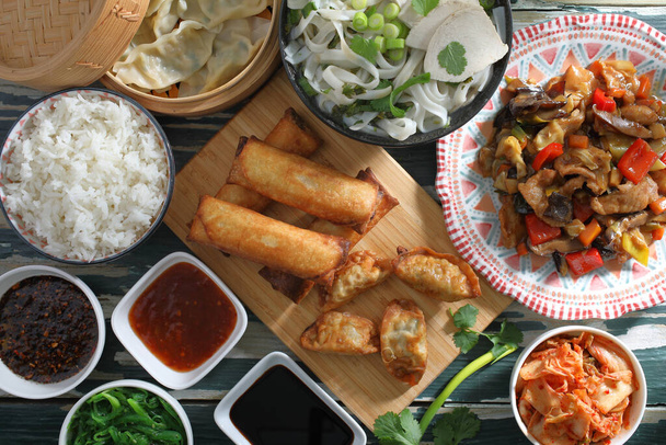 Китайская еда на деревенском зеленом столе - Фото, изображение