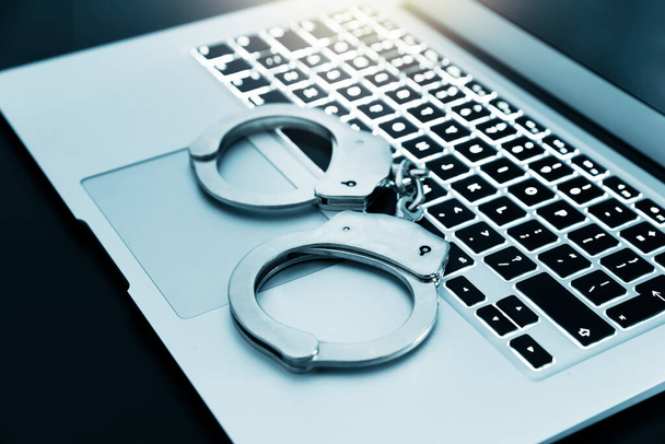 Internet crime concept. Handcuffs on the laptop keyboard, cyber crime concept - Fotoğraf, Görsel