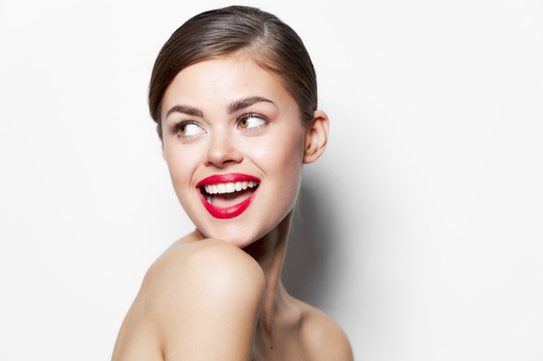 Νεαρή γυναίκα γυμνοί ώμοι χαμόγελο πλάγια ματιά ανοιχτό στόμα κόκκινα χείλη - Φωτογραφία, εικόνα