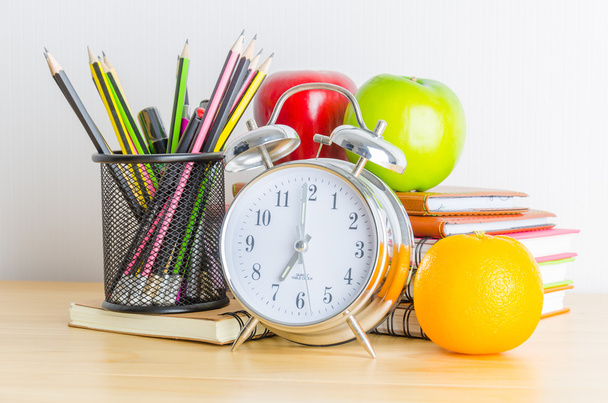 Ritorno a scuola, taccuino, orologio, matita, mela su tavola di legno
 - Foto, immagini