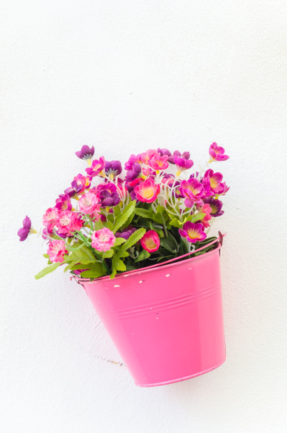 πλαστικών λουλούδι σε βάζο σε φόντο τοίχο - Φωτογραφία, εικόνα