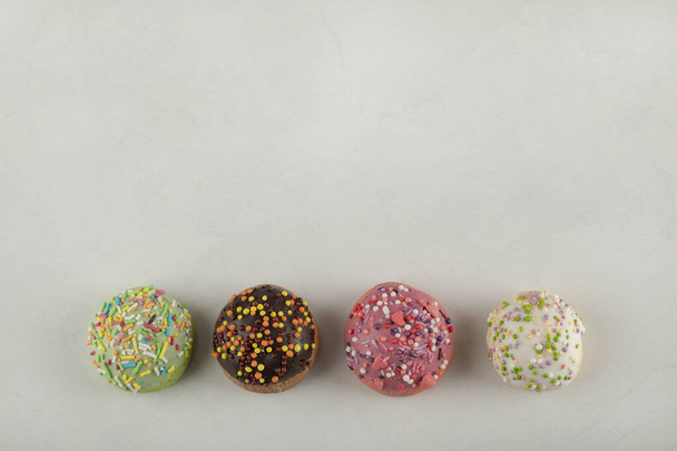 Colorful sweet small doughnuts on a white background - Φωτογραφία, εικόνα