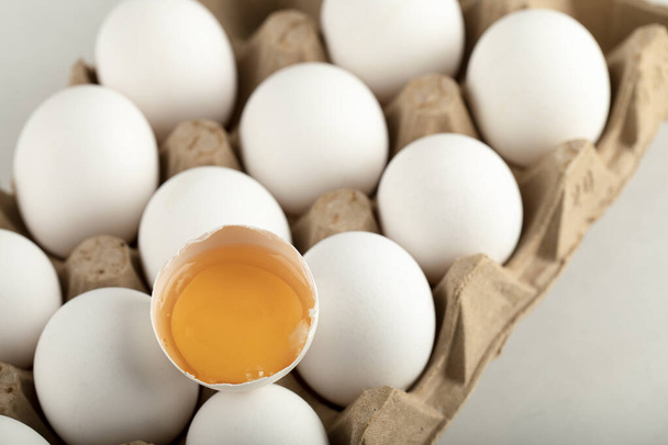 Huevos de pollo crudos en caja de huevo sobre fondo blanco - Foto, imagen
