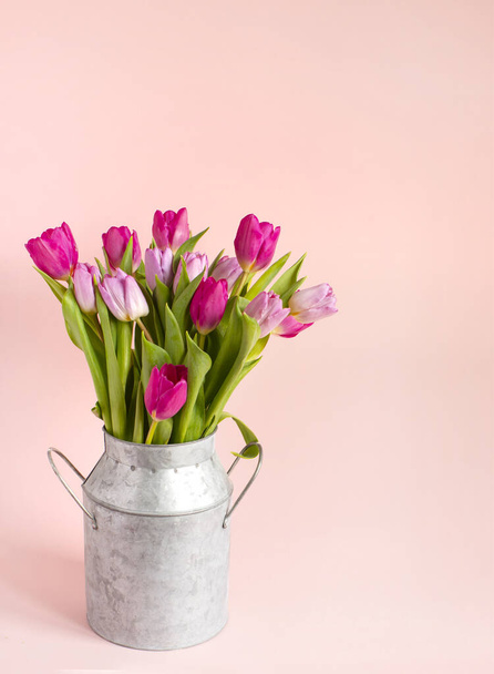 lente roze tulpen boeket in een vaas op roze achtergrond. Vakantie achtergrond, kopieerruimte voor Valentijnsdag, verjaardagsconcept. - Foto, afbeelding