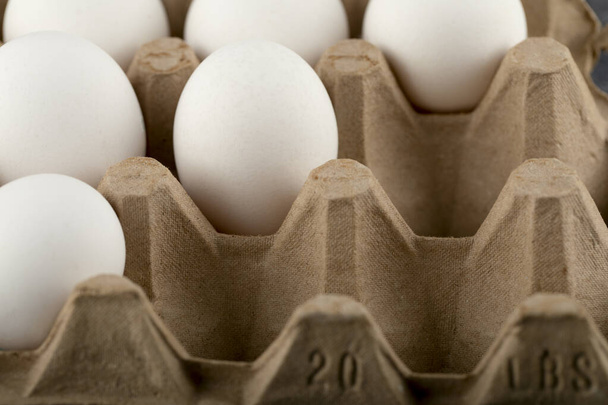Huevos de pollo crudos en caja de huevo sobre fondo de mármol - Foto, imagen